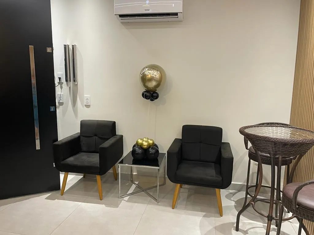 Sala de espera com poltronas pretas.